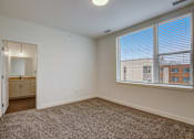 Thumbnail 22 of 30 - A room with a carpeted floor and a window with blinds.