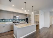 Thumbnail 25 of 30 - A modern kitchen with a marble countertop and stainless steel appliances.