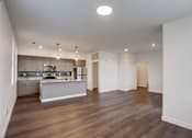 Thumbnail 26 of 30 - A spacious kitchen with a dining area and a living room.