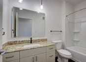 Thumbnail 28 of 30 - A bathroom with a marble countertop and white fixtures.