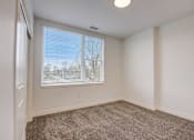 Thumbnail 27 of 30 - A room with a carpeted floor and a window with blinds.