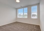 Thumbnail 29 of 30 - A room with carpeted floor and two windows.