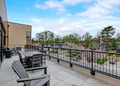 Thumbnail 6 of 30 - A patio with a table and chairs overlooks a residential area.
