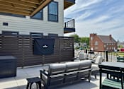 Thumbnail 18 of 31 - A patio with a couch, chairs, and a table.