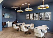 Thumbnail 6 of 26 - A dining room with white chairs and a table.