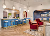 Thumbnail 5 of 26 - A blue bar with stools and a red chair in front of it.