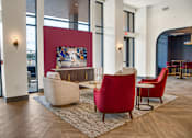 Thumbnail 7 of 26 - A large room with red chairs and a painting on the wall.