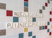 Thumbnail 9 of 26 - A wall with tiles spelling out the words "Welcome to Pine Creek".