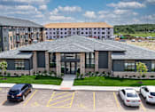 Thumbnail 1 of 26 - A parking lot in front of a building with a sign that says "OFFICE".