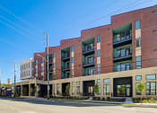 Thumbnail 7 of 26 - a large brick building with many windows and a street in front of it
