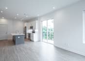 Thumbnail 18 of 23 - A kitchen with a sink and a refrigerator in a white room.