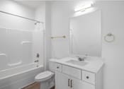Thumbnail 16 of 23 - A white bathroom with a toilet, sink, and bathtub.
