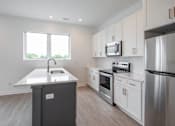 Thumbnail 13 of 23 - A kitchen with a stainless steel refrigerator, oven, and microwave.
