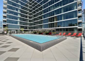 Thumbnail 6 of 22 - a swimming pool in front of a tall building