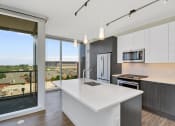 Thumbnail 1 of 22 - an open kitchen with a large white island and a large window