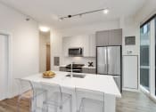 Thumbnail 4 of 22 - a kitchen with a white counter top and a stainless steel refrigerator