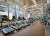Thumbnail 10 of 22 - a gym with cardio machines and a view of the city