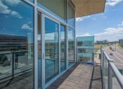 Thumbnail 3 of 33 - a balcony with glass doors and a view of the city