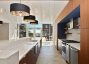 Thumbnail 14 of 22 - a kitchen with white countertops and stainless steel appliances and a blue accent wall