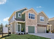Thumbnail 1 of 16 - A modern two-story house with a garage and a driveway.