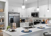 Thumbnail 6 of 35 - a kitchen with a large counter and a stainless steel refrigerator