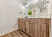 Thumbnail 43 of 48 - A bathroom vanity with a mirror and lights above it.
