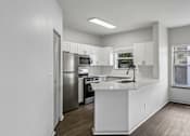 Thumbnail 11 of 61 - A kitchen with white cabinets and a stainless steel refrigerator.