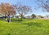 Thumbnail 8 of 35 - St. Vincent Greenbriar, Indianapolis, IN, Apartments - The Jameson - An Outdoor Fenced-In Dog Park in a Large Grassy Area with Trees and a Pet-Waste Station.