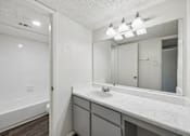 Thumbnail 12 of 21 - A bathroom with a white sink and a large mirror.