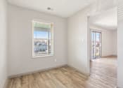 Thumbnail 24 of 35 - A room with a window and wooden flooring.