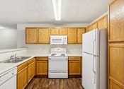 Thumbnail 11 of 58 - A kitchen with wooden cabinets and white appliances.