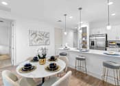 Thumbnail 5 of 35 - an open kitchen and dining area with a table and chairs