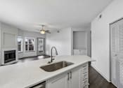 Thumbnail 13 of 61 - A modern kitchen with a white countertop and a stainless steel sink.