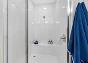 Thumbnail 13 of 35 - a bathroom with a shower and blue towels