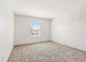 Thumbnail 20 of 35 - A room with a carpeted floor and a window with blinds.