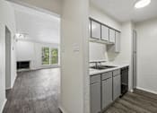 Thumbnail 4 of 21 - A kitchen with a sink, stove, and cabinets.