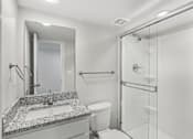 Thumbnail 9 of 16 - A bathroom with a sink, toilet, and shower.