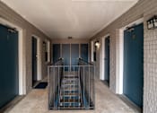 Thumbnail 1 of 11 - A staircase with a metal railing leads to a door with the number 8 on it.