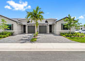 Thumbnail 2 of 35 - a house with a driveway and a palm tree in front of it