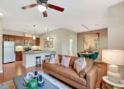 Thumbnail 6 of 48 - a living room and kitchen with a couch and a ceiling fan