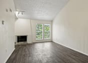 Thumbnail 6 of 21 - A large empty room with a fireplace and sliding glass doors.