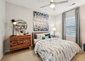 Thumbnail 23 of 64 - A bedroom with a bed, nightstand, and a ceiling fan.