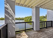 Thumbnail 19 of 61 - A wooden deck with a metal railing and a concrete pillar.