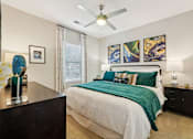 Thumbnail 21 of 64 - A bedroom with a bed, nightstand, and a ceiling fan.