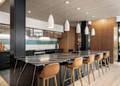 Thumbnail 38 of 41 - A modern kitchen with a long island and chairs.
