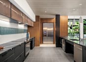 Thumbnail 37 of 41 - A modern kitchen with a stainless steel refrigerator and black cabinets.