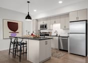 Thumbnail 2 of 41 - A modern kitchen with a large island and stainless steel appliances.