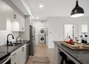 Thumbnail 4 of 41 - A modern kitchen with a black countertop and stainless steel appliances.