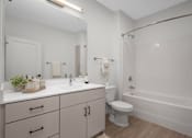 Thumbnail 9 of 41 - A white bathroom with a toilet, sink, and bathtub.
