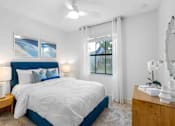Thumbnail 11 of 35 - a bedroom with a blue and white bed and a window